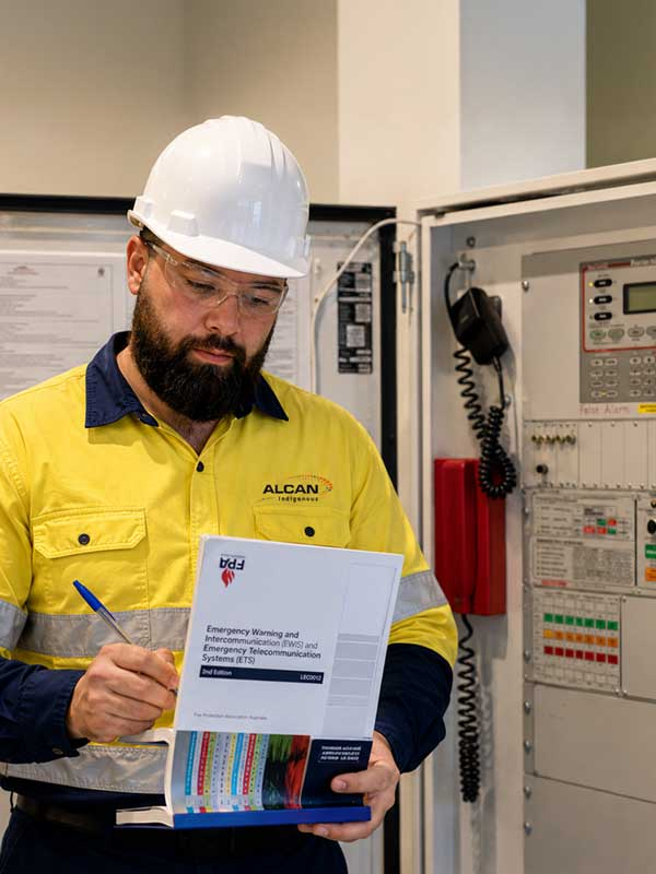 Terrence inspecting an EWIS fire safety control panel during a fire protection system inspection in Perth, Western Australia.